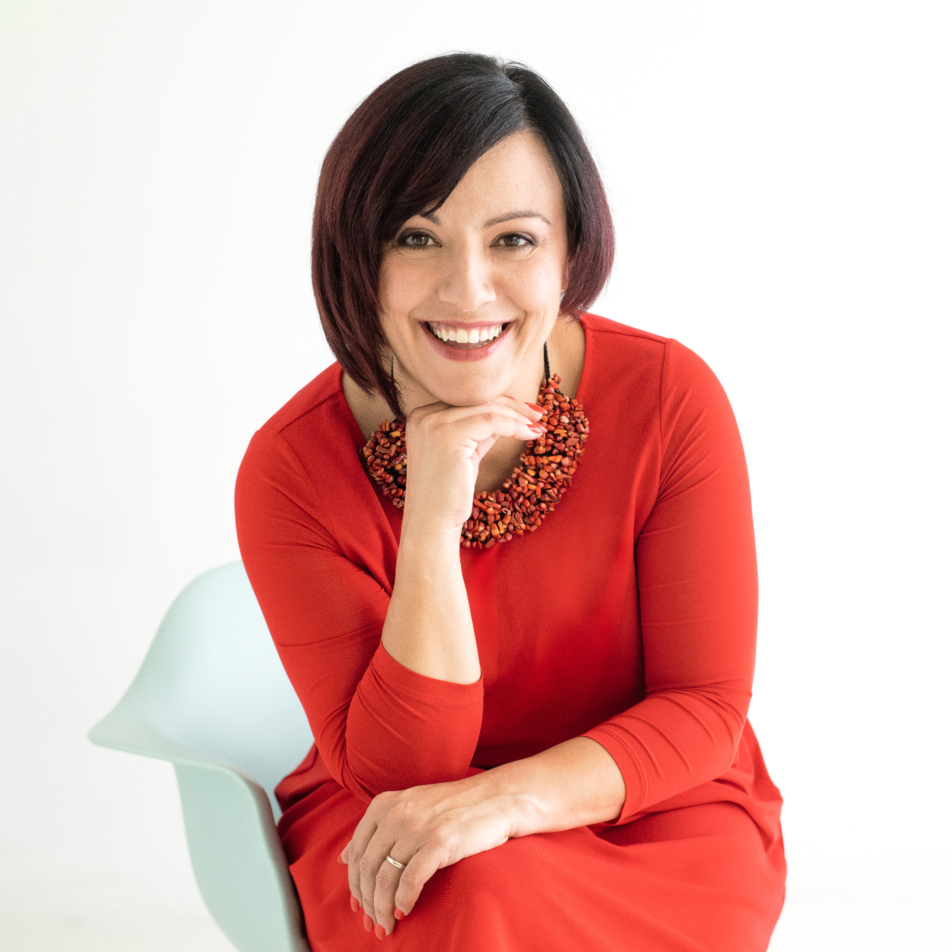 Irene Magistro in a red dress with statement necklace